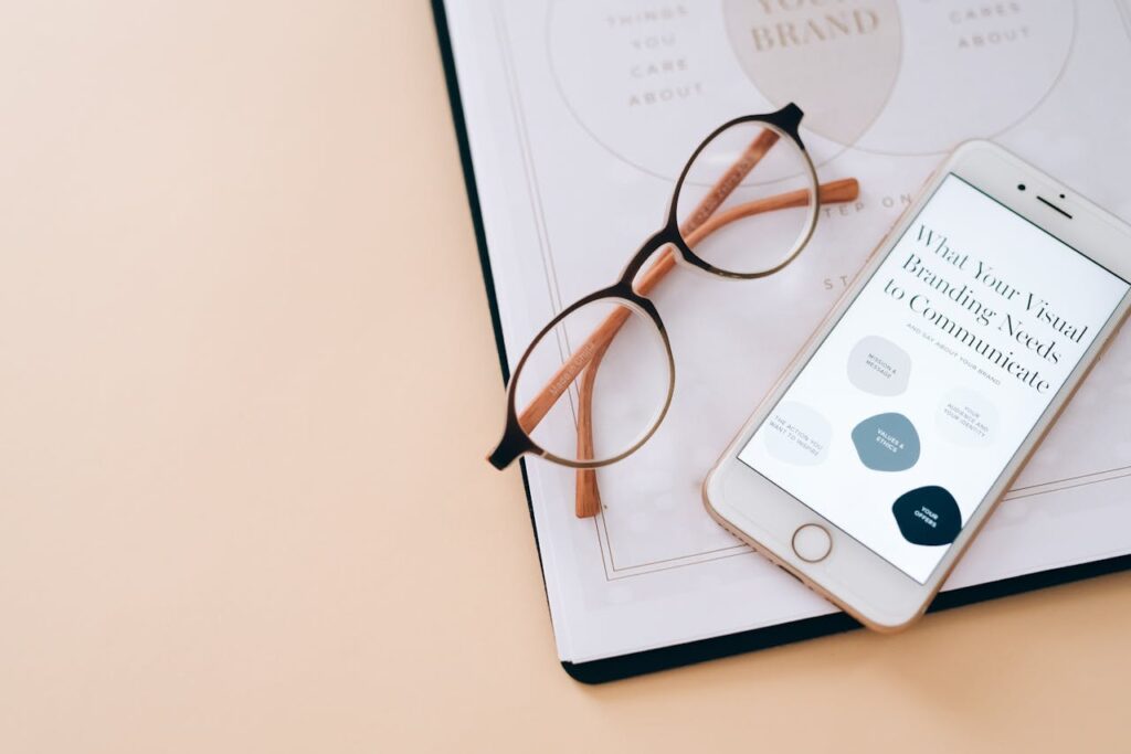 pexels-photo-8970668 Stylish flat lay of eyeglasses, smartphone, and branding document on a desk.