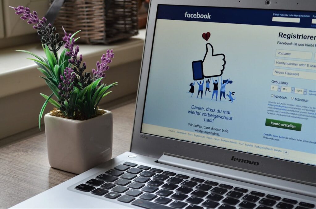 pexels-photo-927629 A Lenovo laptop displaying Facebook login beside a lavender plant indoors.